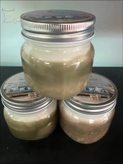 Selected Scent all natural masculine candle in glass jars with silver lids arranged in a pyramid on black surface