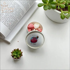Selected Scent love spell wax melts in white tin with pink heart shaped melts beside book and succulents