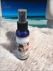 Selected Scent Love Spell long-lasting linen spray for home in a blue spray bottle on a fluffy surface