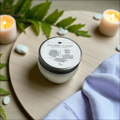 Selected Scent massage candle with mango butter in glass jar on wooden tray with candles and green leaves