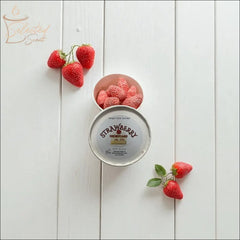 Selected Scent strawberry wax melts for fragrance in a round container with fresh strawberries on white wooden background