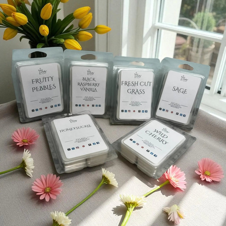 Wax melts for home fragrance in various scents including fruity pebbles and wild cherry displayed with flowers near a window