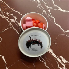 Selected Scent tin of dragons blood wax melts with pink and red cube melts on marble surface