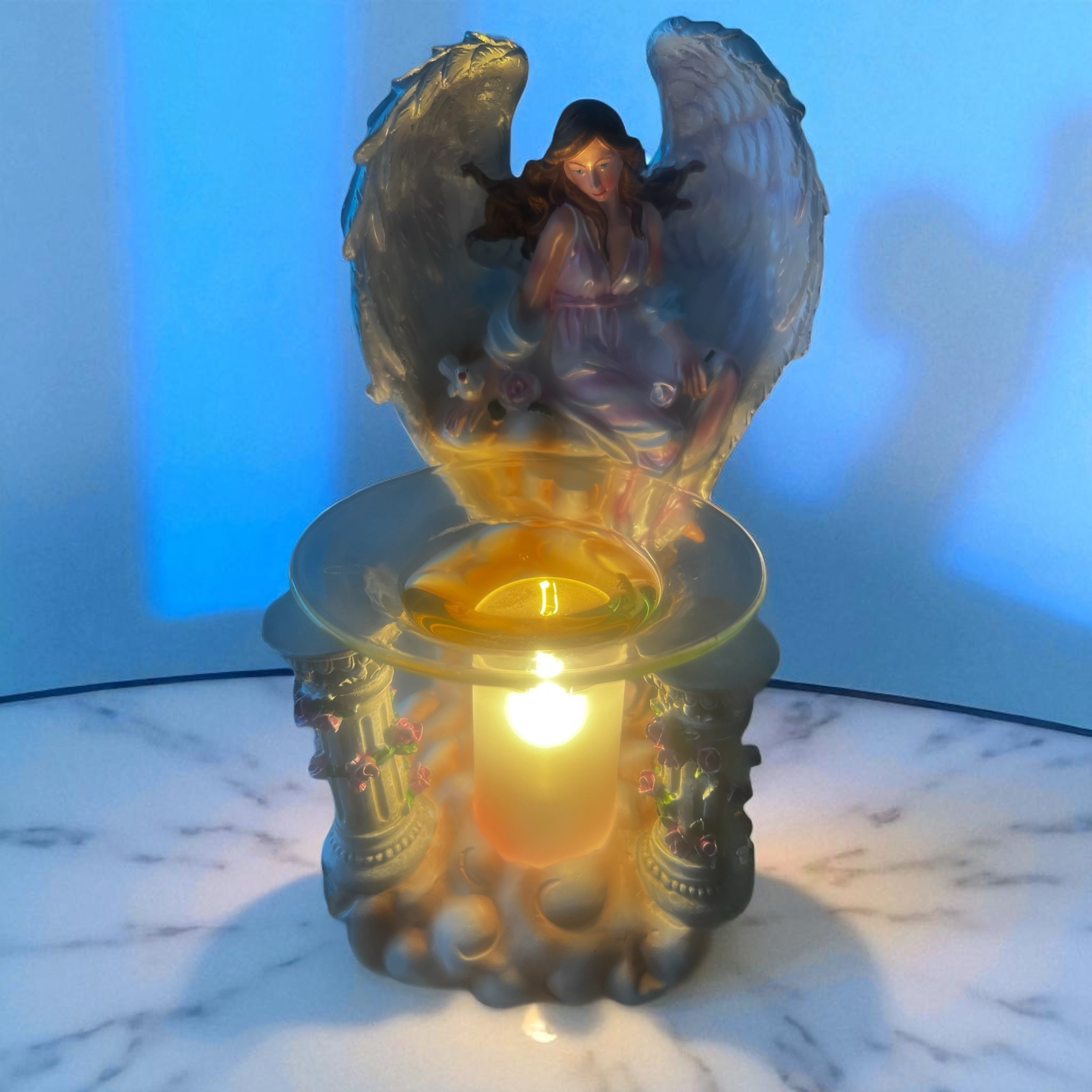 Selected Scent electric decorative warmer with angel figurine and glowing light on marble surface