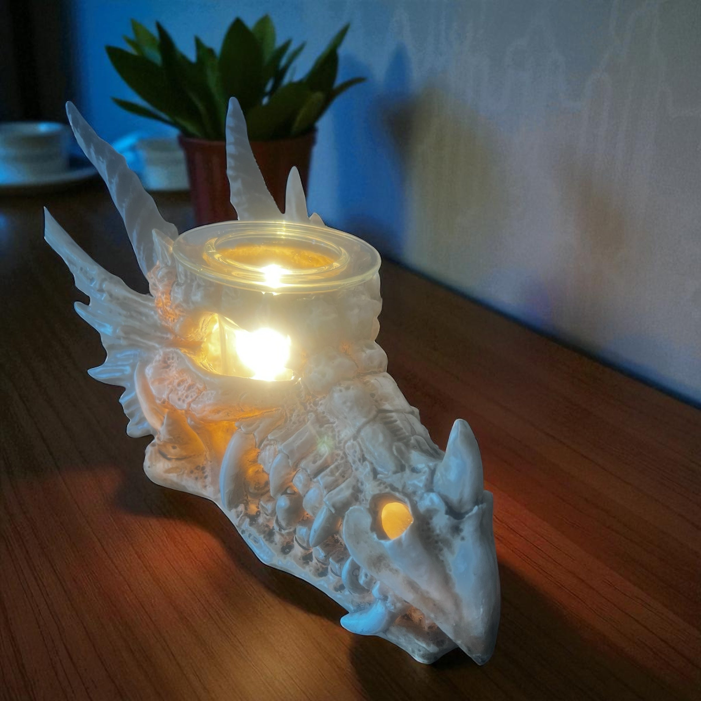 Selected Scent electric decorative warmer shaped like a dragon skull with glowing light on wooden surface