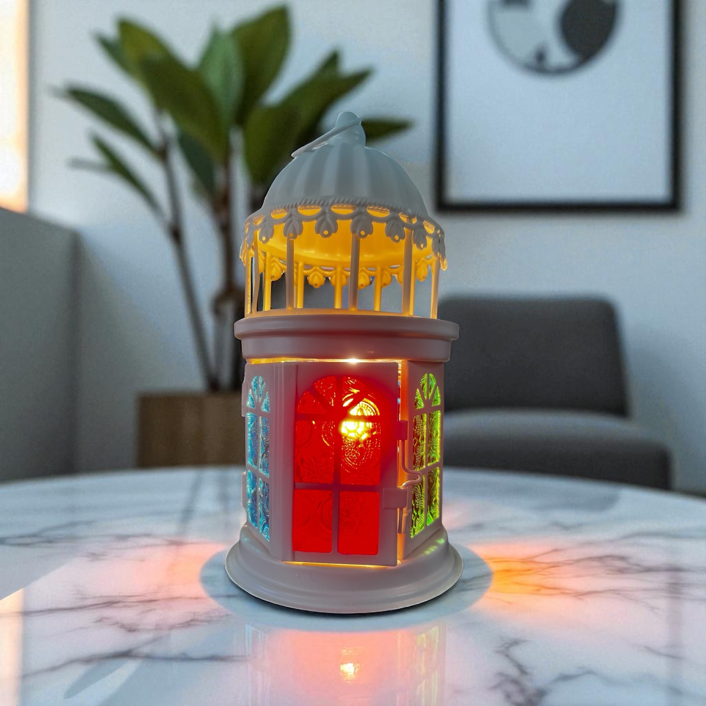 Selected Scent electric decorative warmer shaped like a lantern with colorful glowing windows on a marble table