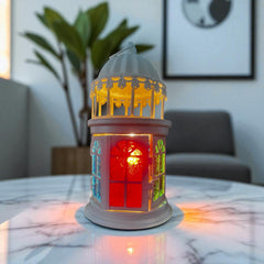 Selected Scent electric decorative warmer shaped like a lantern with colorful glowing windows on a marble table