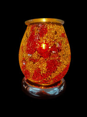 Selected Scent electric decorative warmer with red and gold mosaic glass design lit on black background