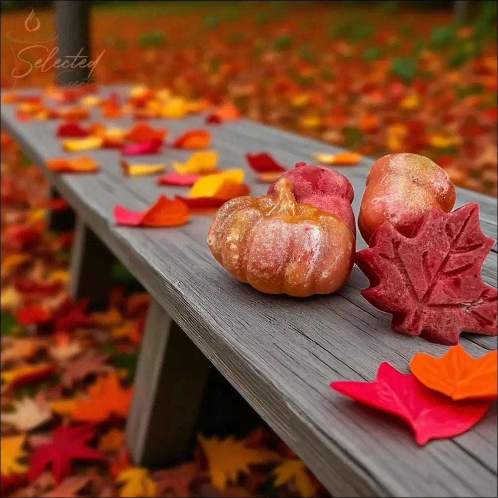 Selected Scent pumpkin and leaves wax melts arranged on a gray wooden bench among colorful fall leaves