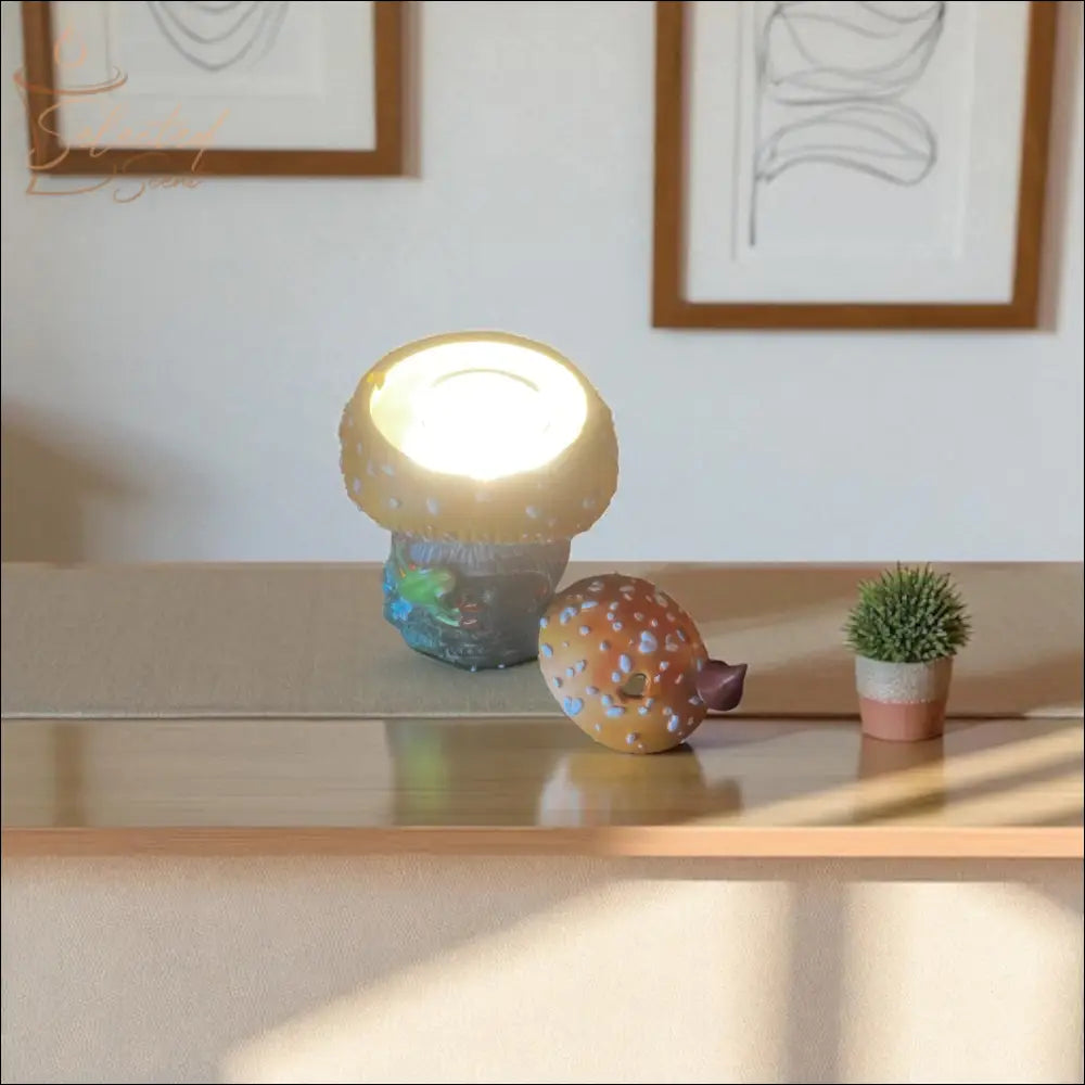 Selected Scent frog and mushroom wax warmer with lighted top on table near small plant