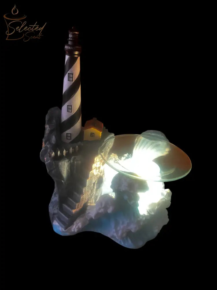 Selected Scent Electric Decorative Warmer shaped like a lighthouse with a glowing light and detailed rocky base