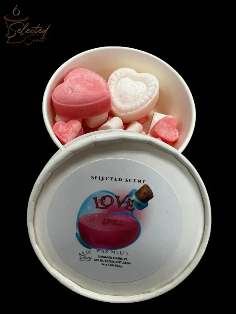 Selected Scent love spell wax melts in a white round tin showing pink and white heart shaped wax pieces