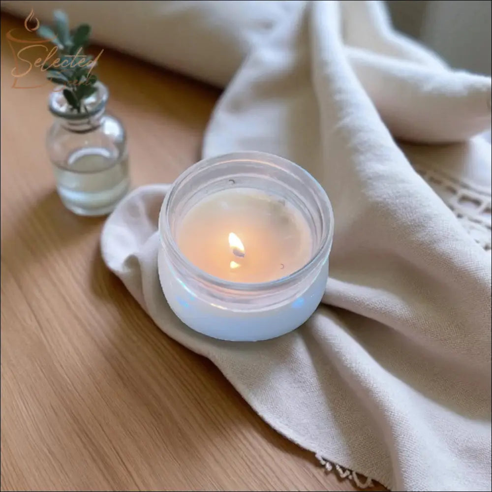 Selected Scent scented candle with mango butter burning next to a small glass vase on a wooden surface