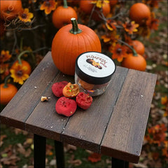 Selected Scent autumn scented home wax melts jar with red wax pieces on wooden table by pumpkin