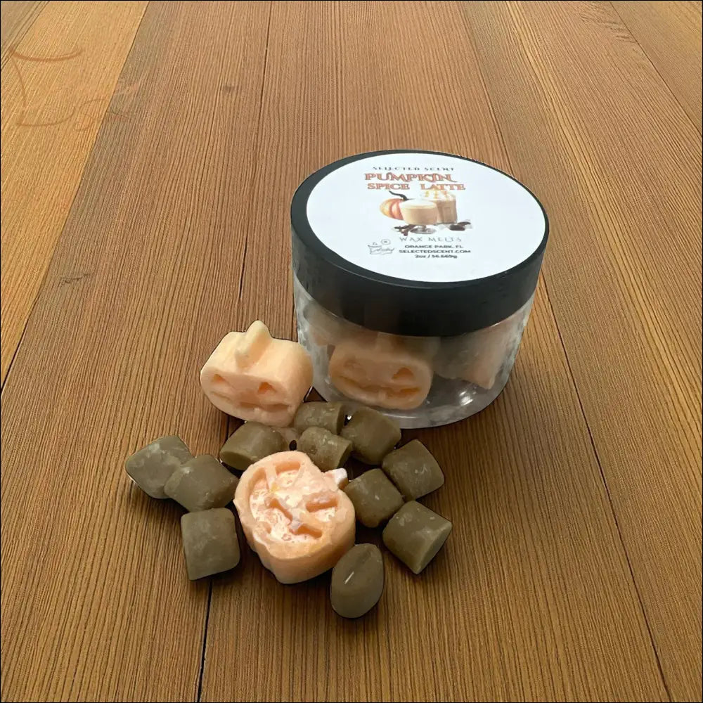 Selected Scent jar of pumpkin spice latte wax melts with peach jack o lantern shapes and brown cubes on wood surface