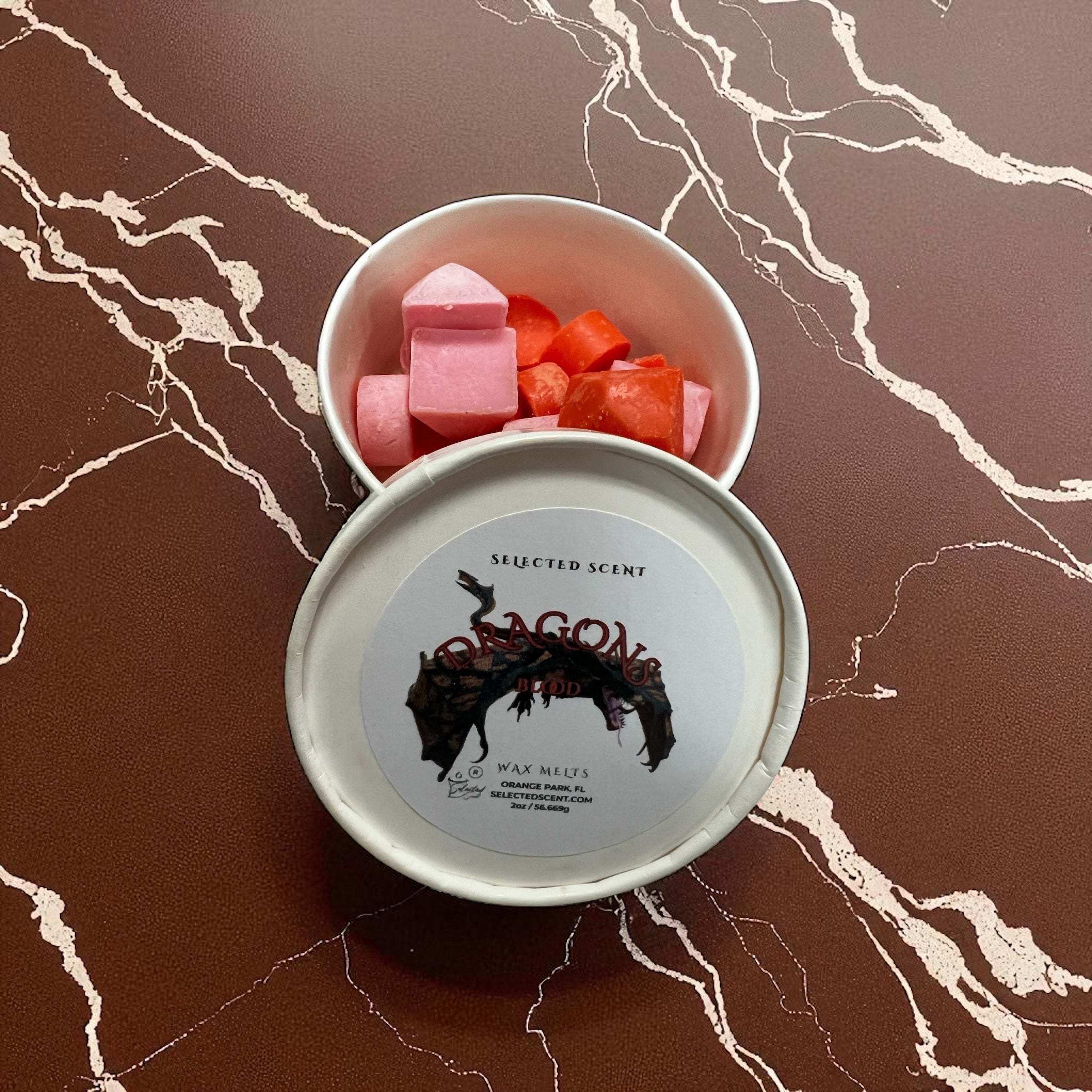 Selected Scent tin of dragons blood wax melts with pink and red cube melts on marble surface