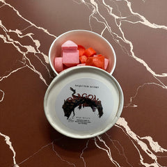 Selected Scent tin of dragons blood wax melts with pink and red cube melts on marble surface
