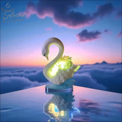 Selected Scent electric decorative warmer shaped like a glowing swan on reflective surface at sunset