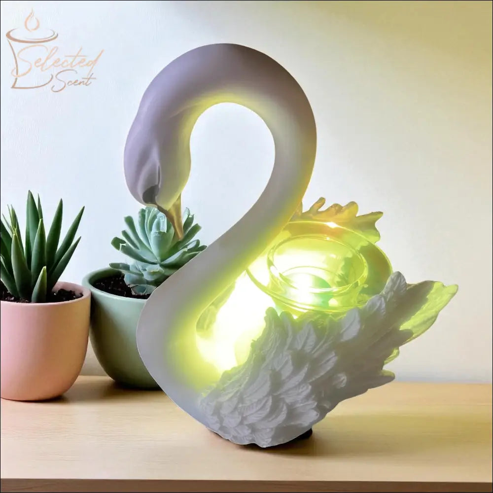 Selected Scent Electric Decorative Warmer shaped like a white swan glowing on wooden surface with small potted succulents