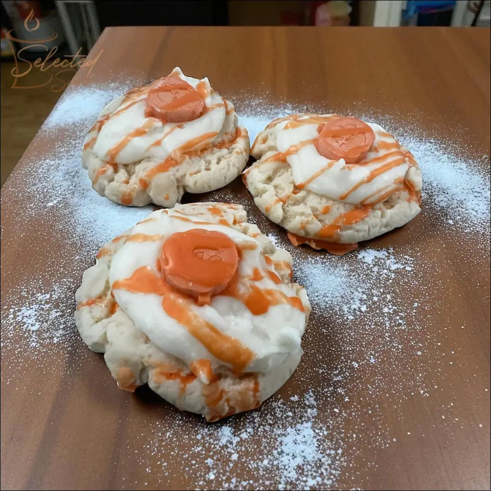 Selected Scent three handcrafted vanilla pumpkin spice wax melts resembling frosted cookies with orange drizzle
