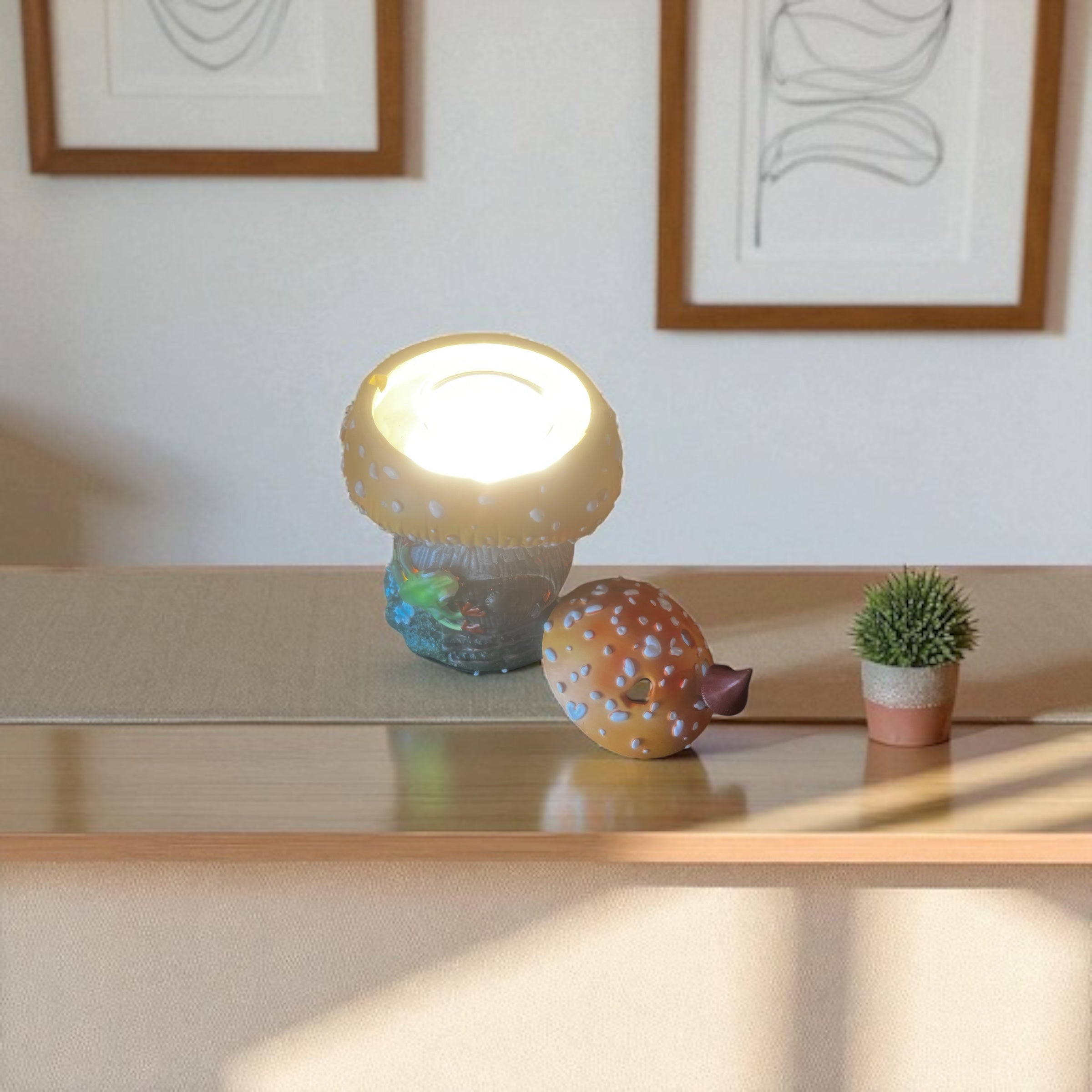 Selected Scent frog and mushroom wax warmer with lighted top on table near small plant